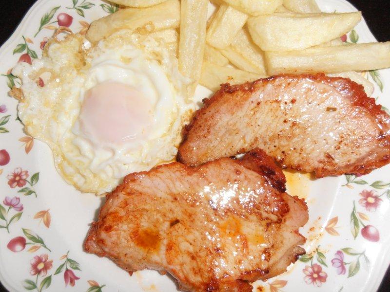 Lomo adobado casero, patatas fritas y huevo.